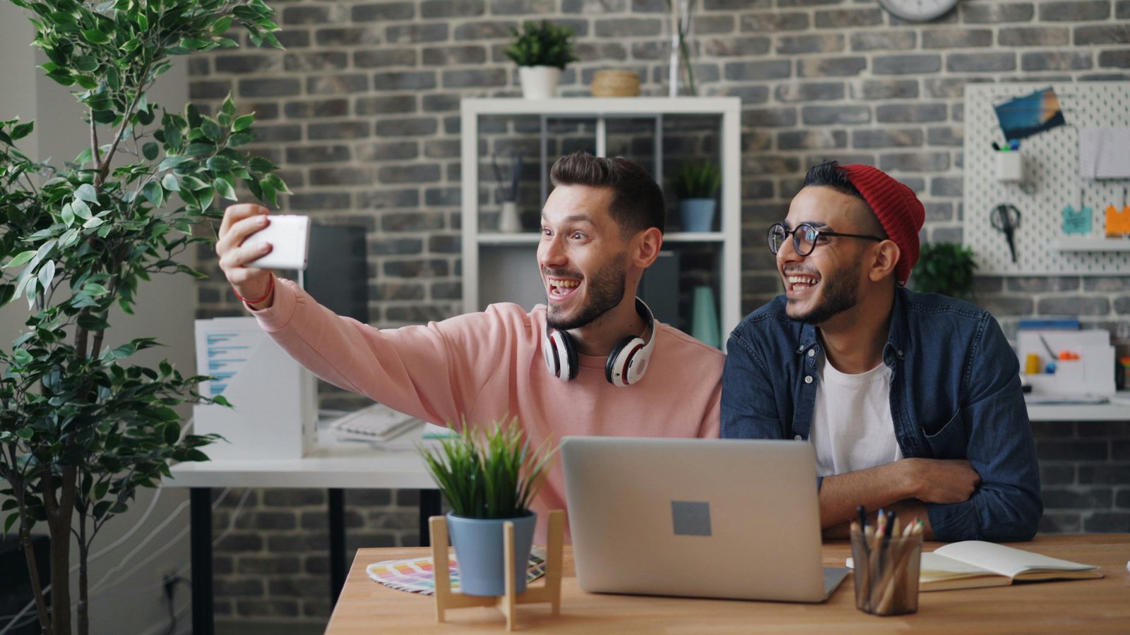 Two men taking a selfie in front of a desk